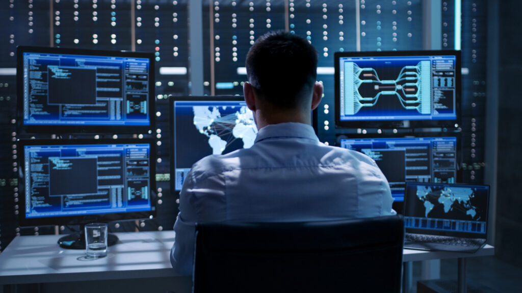 IT security and network management specialist monitoring servers in control room to prevent cyber threats 